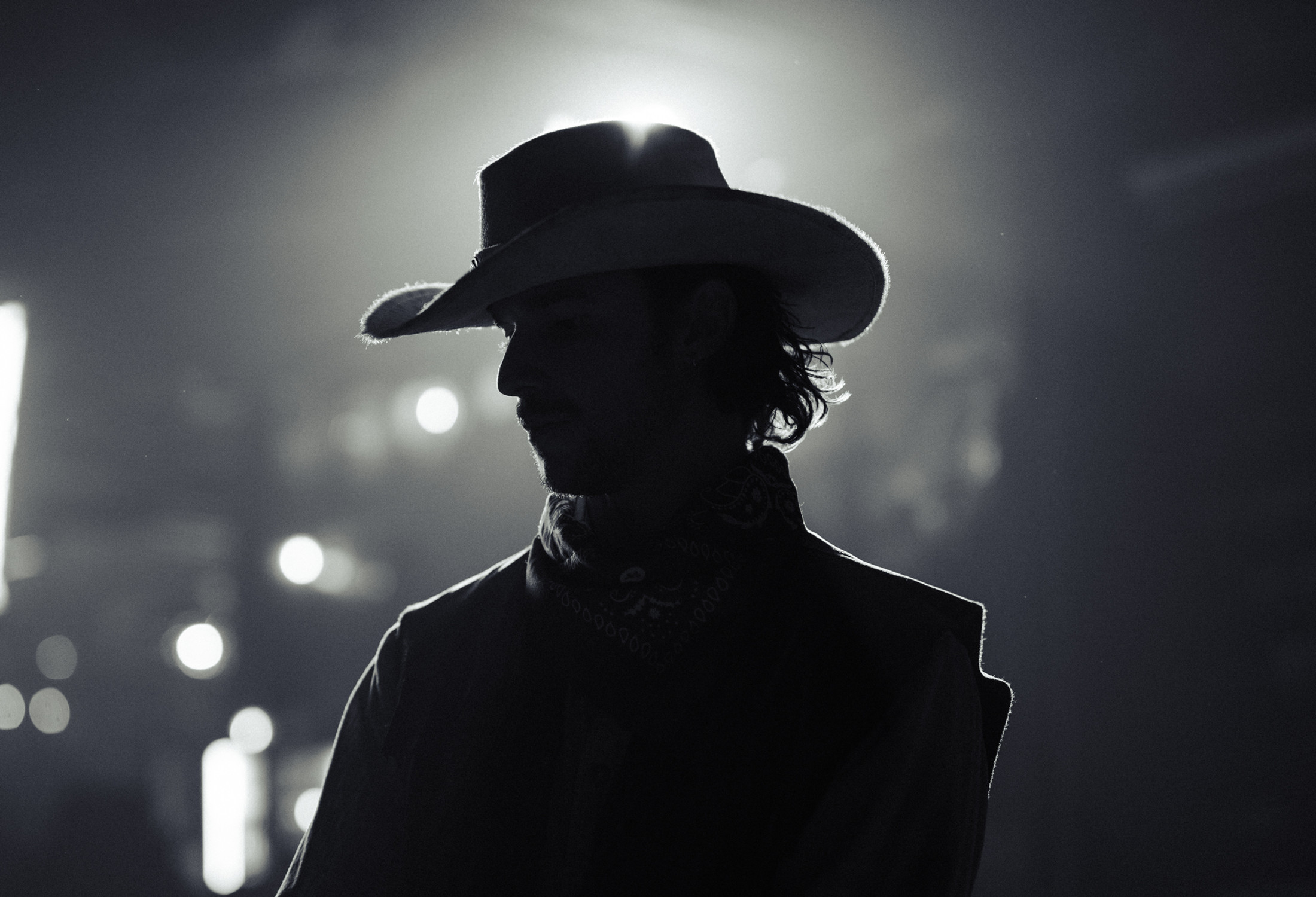 Backlit silhouette in a cowboy hat on stage