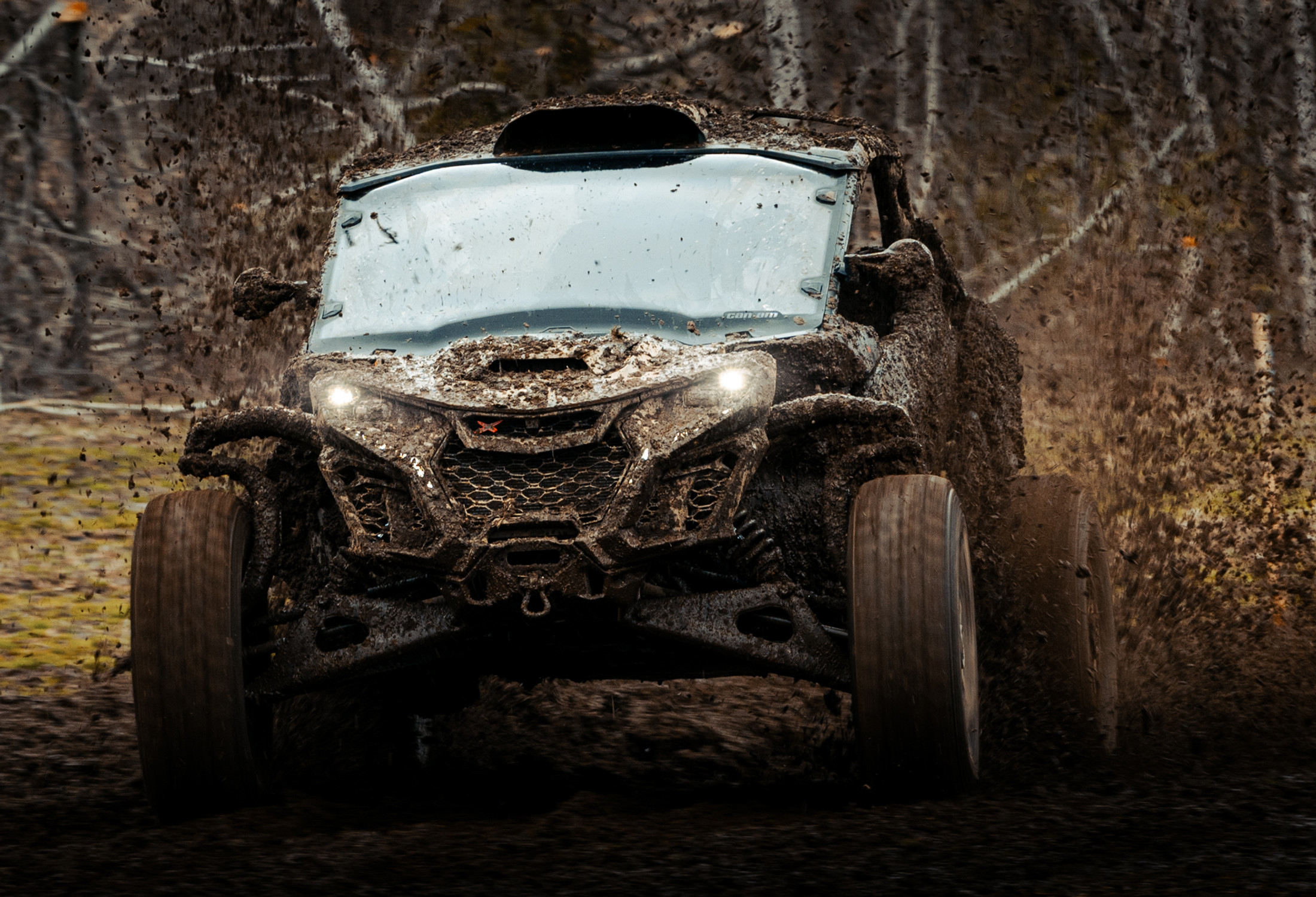 Can-Am Maverick covered in mud, mid-run